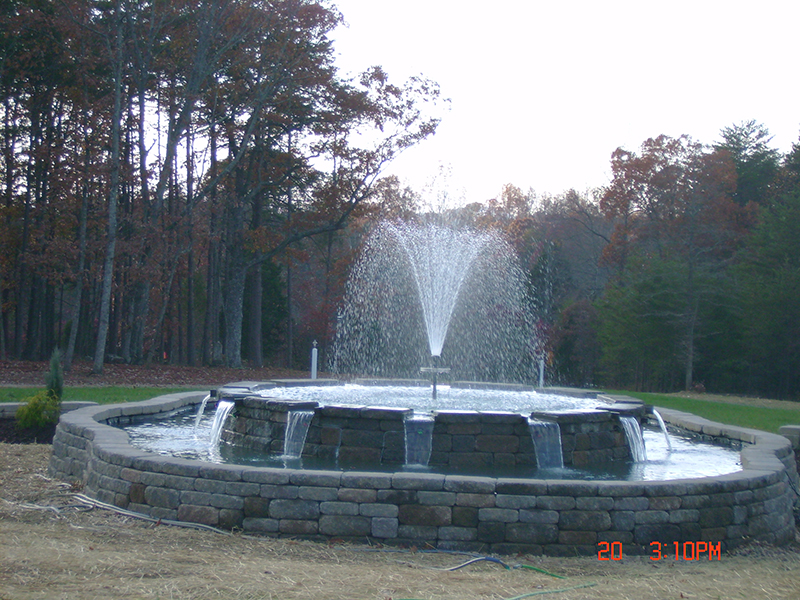 Natural stone pond with cascading waterfall and ornamental grasses